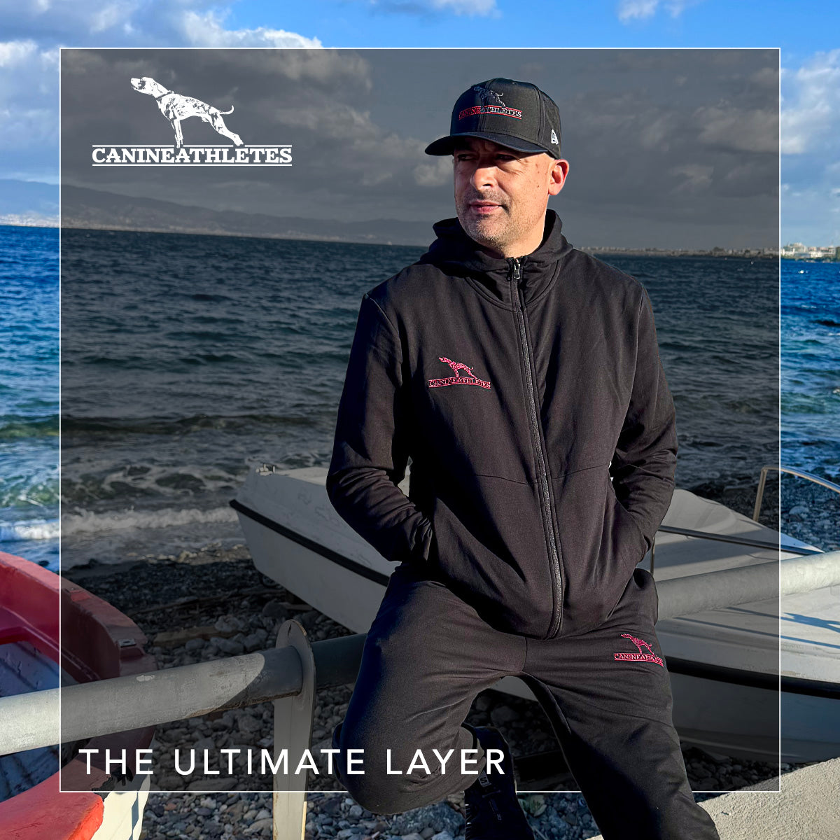 Man wearing a branded jacket and cap by the water with &#39;Canine Athletes&#39; branding.